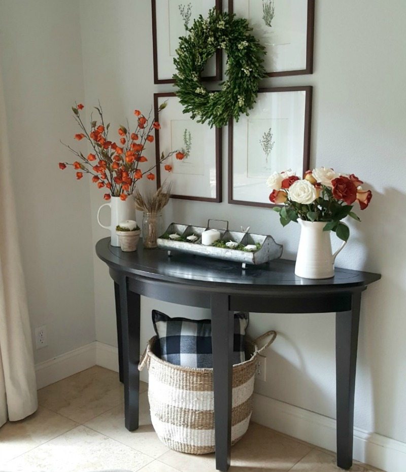 console vignette with orange flowers and wreath