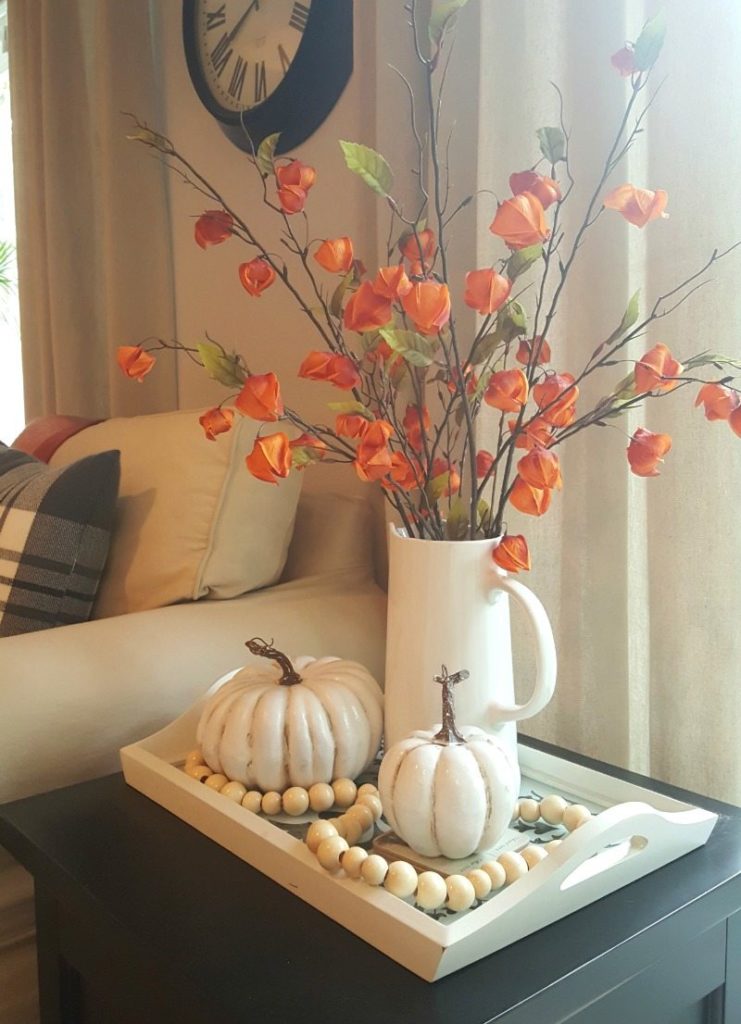 fall vignette with orange florals and pumpkins