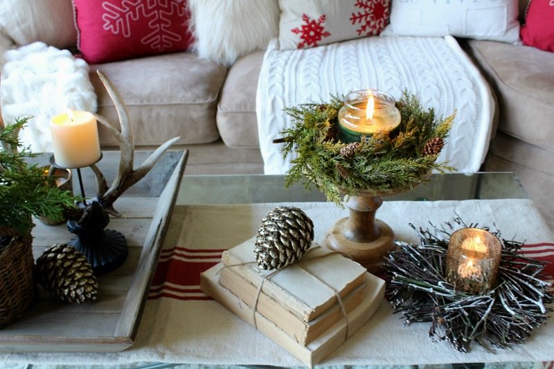 Use rustic elements to create a cozy traditional appeal to your holiday decor with evergreen, pine cones, and antlers