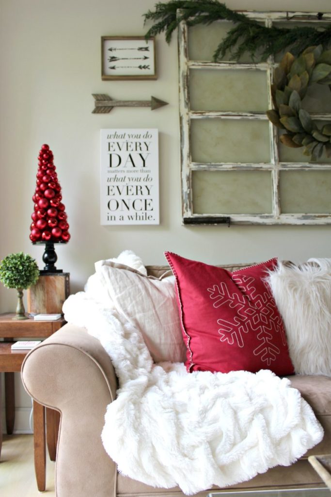 Holiday decorating with rustic farmhouse details add warmth to traditional family room decor with red, white and green accents