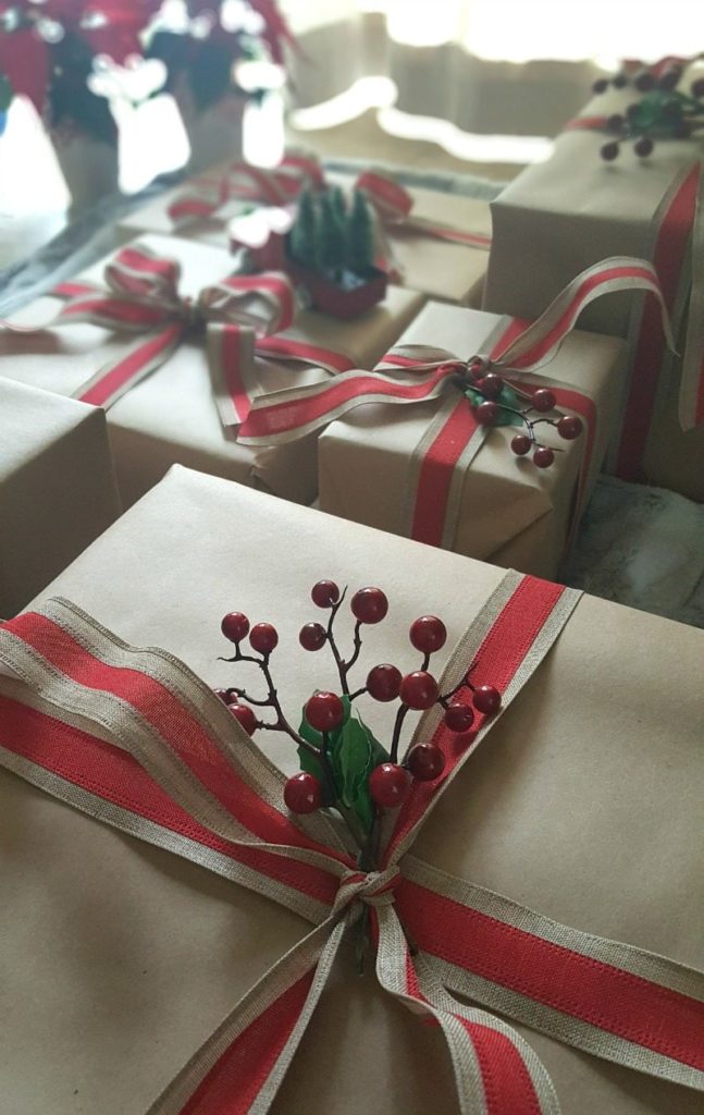 brown paper packages with holly and red ribbon close up