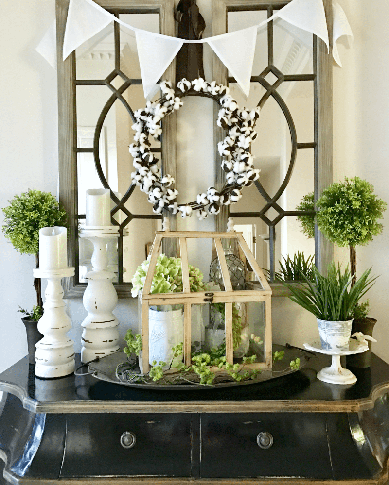 black console with greenery entryway decorating
