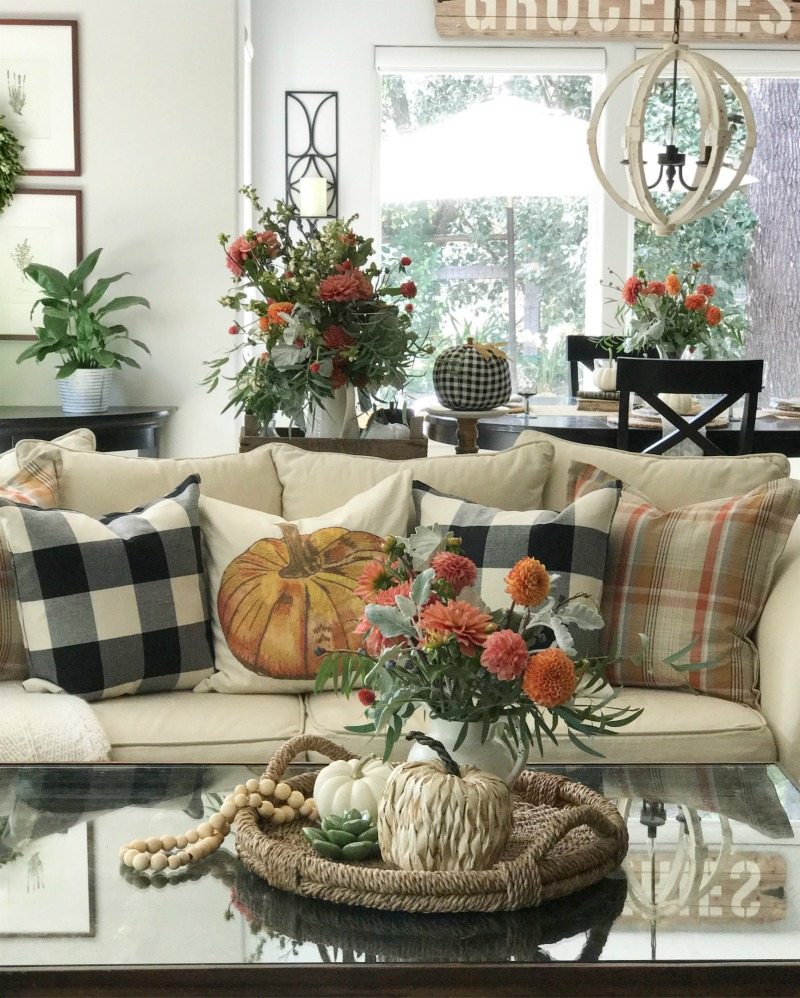 pumpkin and plaid pillows with flowers in living room