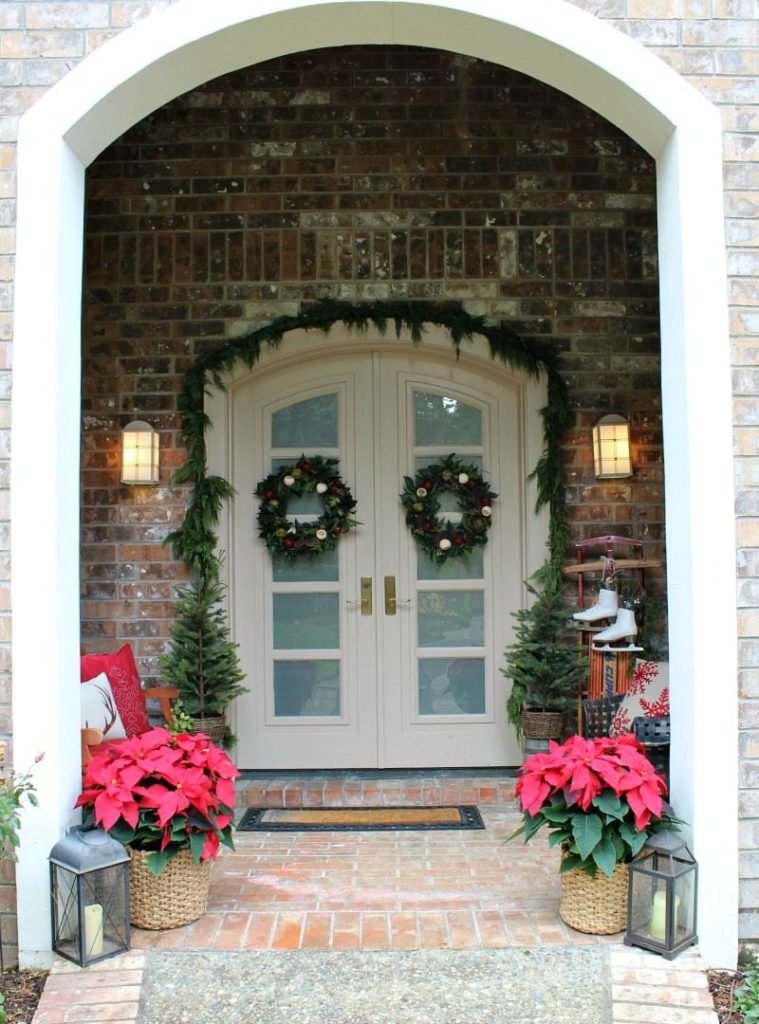Create Christmas Decor Magic with poinsettas and evergreen garlands