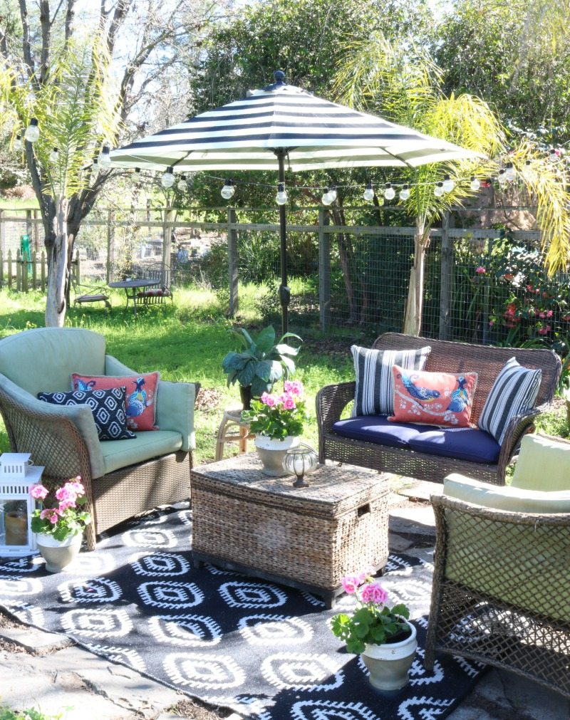 outdoor seating area with umbrella and rug