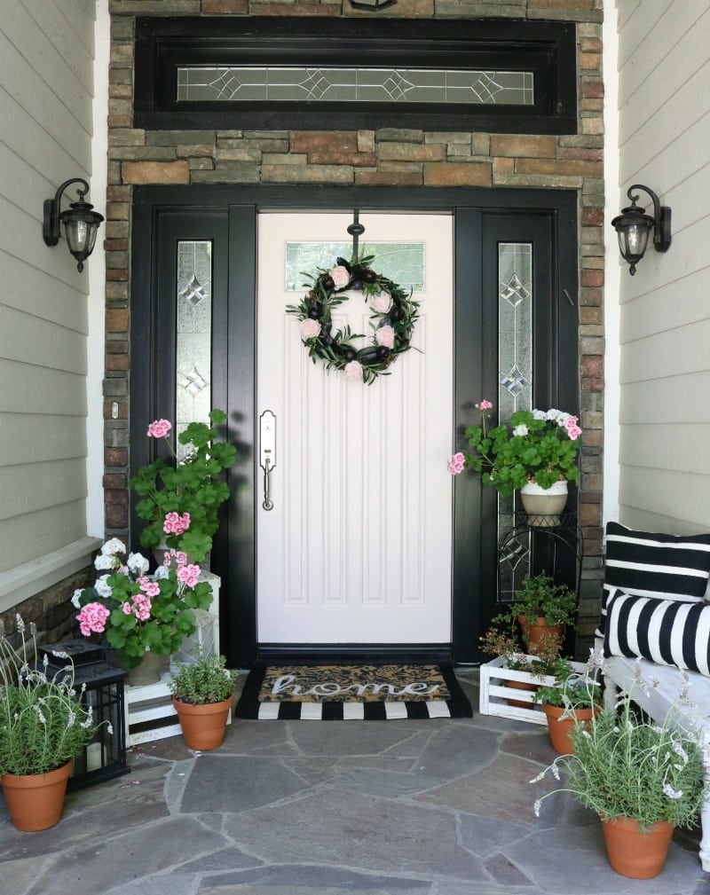 pink painted front door and striped accents and flowers