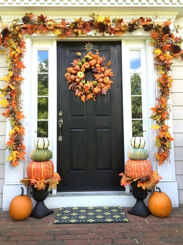 fall front porch with leaf garland and pumpkins