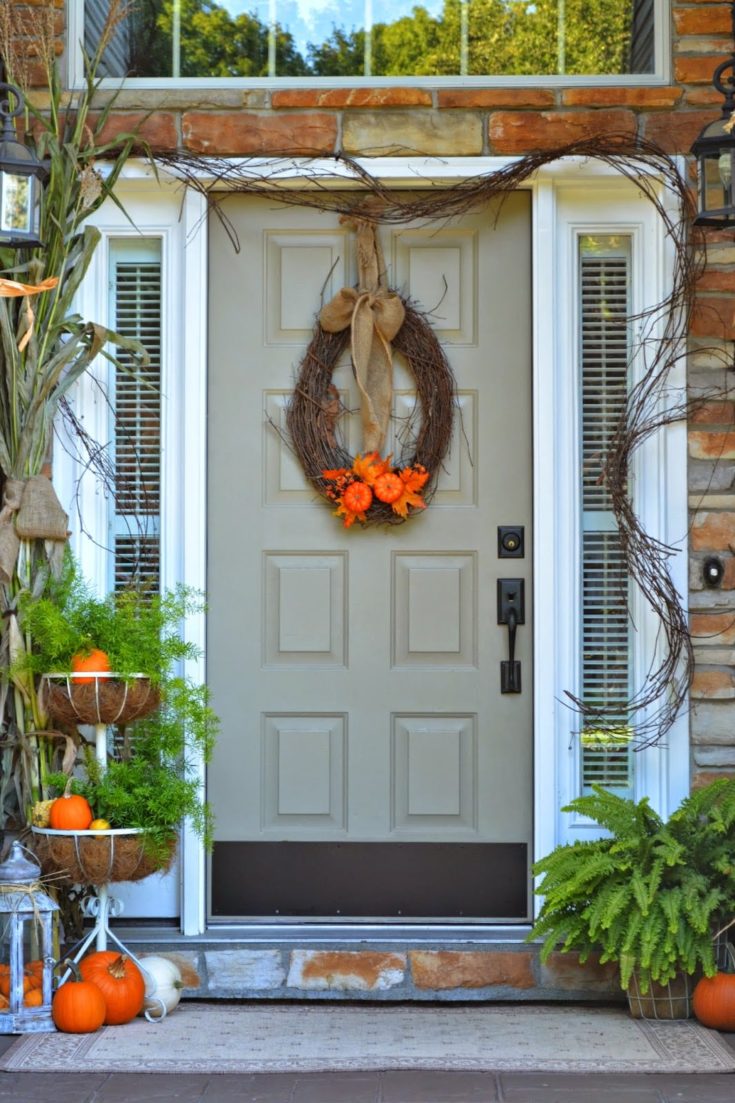 Pumpkins and natural twine decorate front porch and door for fall