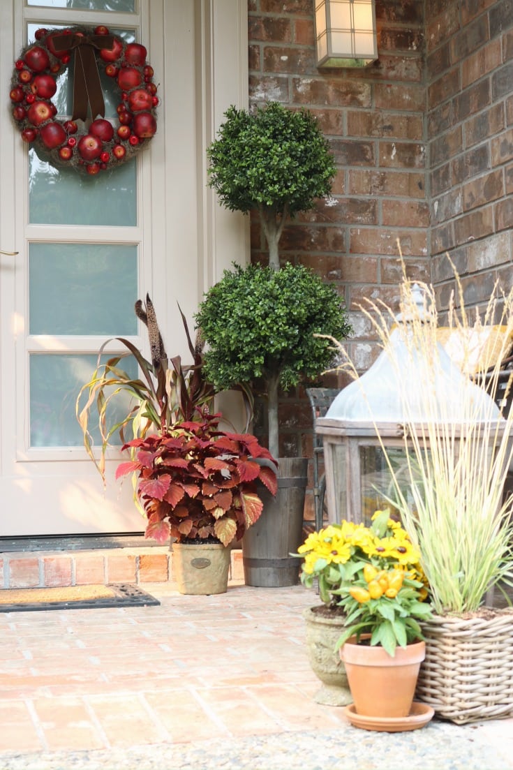 fall front door porch with greenery and lanterns