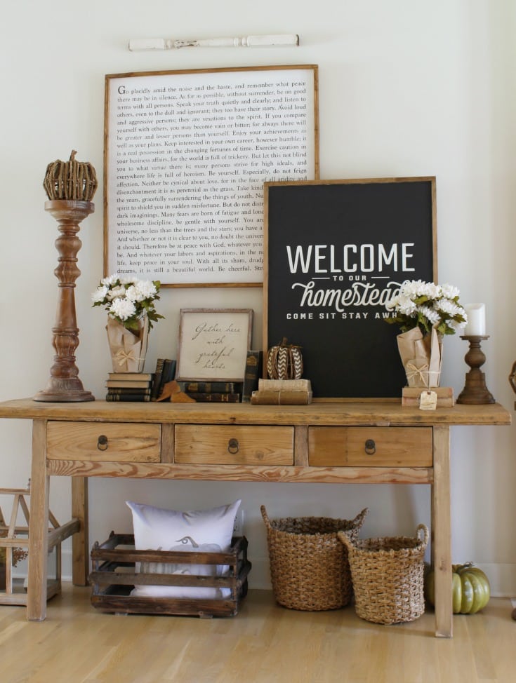 fall farmhouse table vignette with pillows and baskets and signs