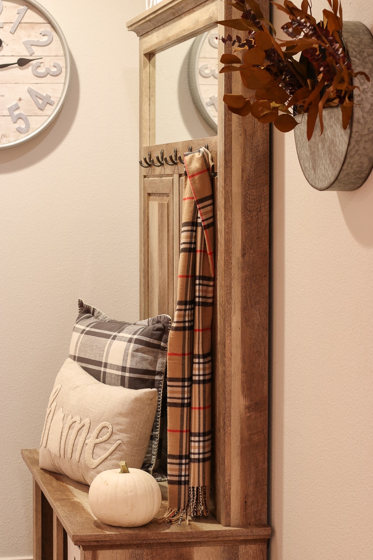 Stylish Entryway Bench and Storage Unit decorated for fall with plaid pillows and pumpkins