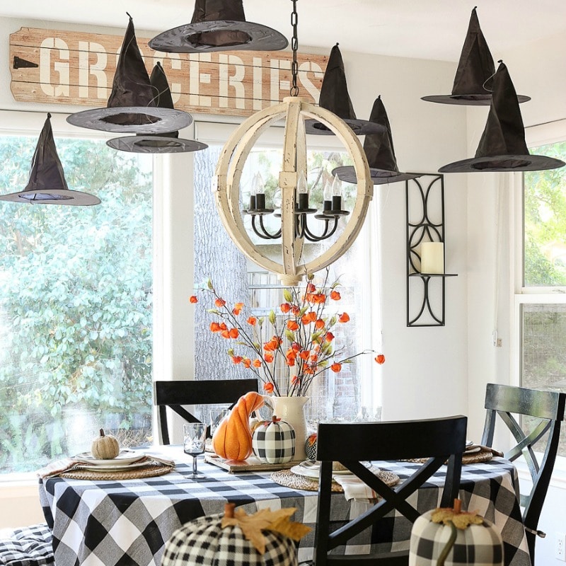 Floating witches hats and buffalo plaid make this festive table Halloween ready!