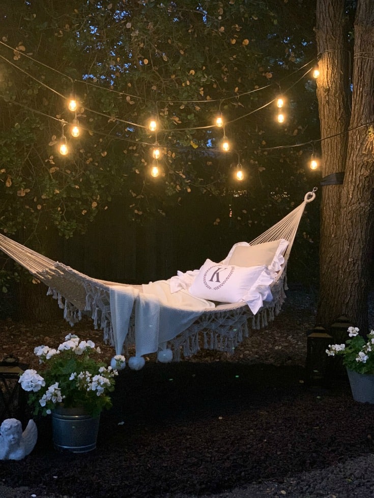 hammock with string lights and pom pom throw at night