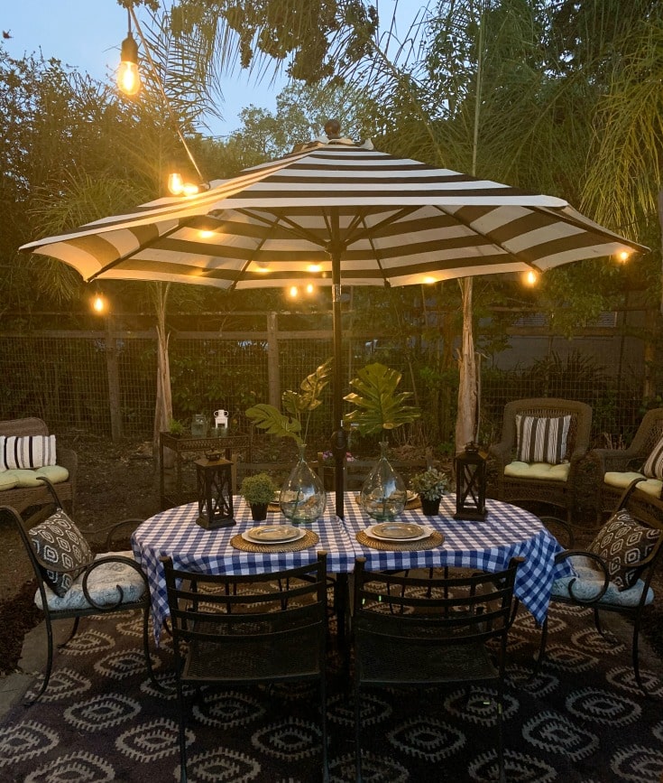 beautiful outdoor table with striped umbrella and picnic table cloth