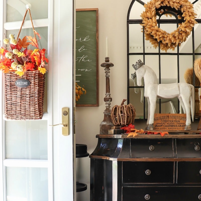 Warm fall botanical leaves and wreath decorate the door and entryway