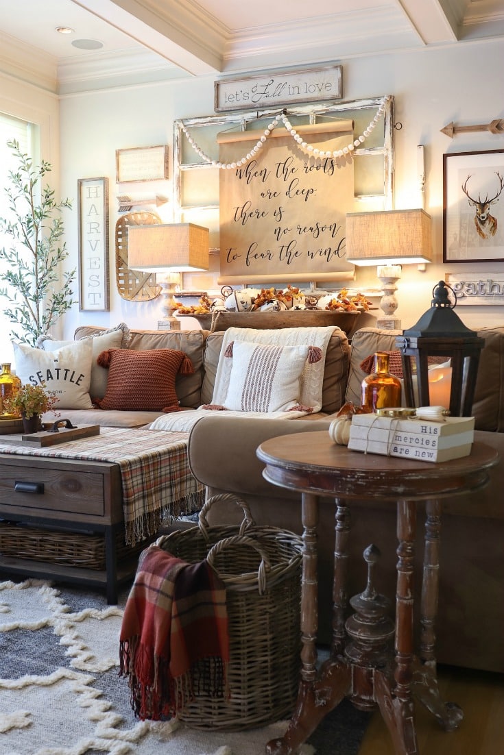 Rich hues, warm plaid blankets, and layers of textured decor create inviting fall living room decor