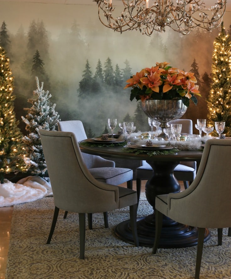 holiday dining room decor is extra festive with backdrop of forest wall mural and twinkling Christmas trees