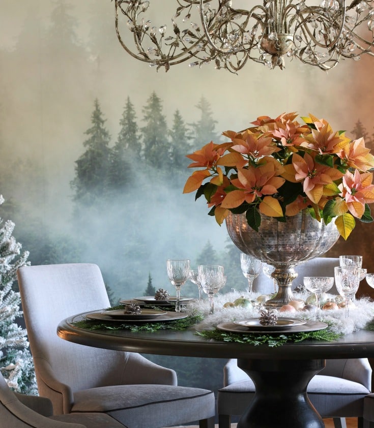 natural elements like wood table and evergreen placemats contrast with elegant crystal chandelier and glasses