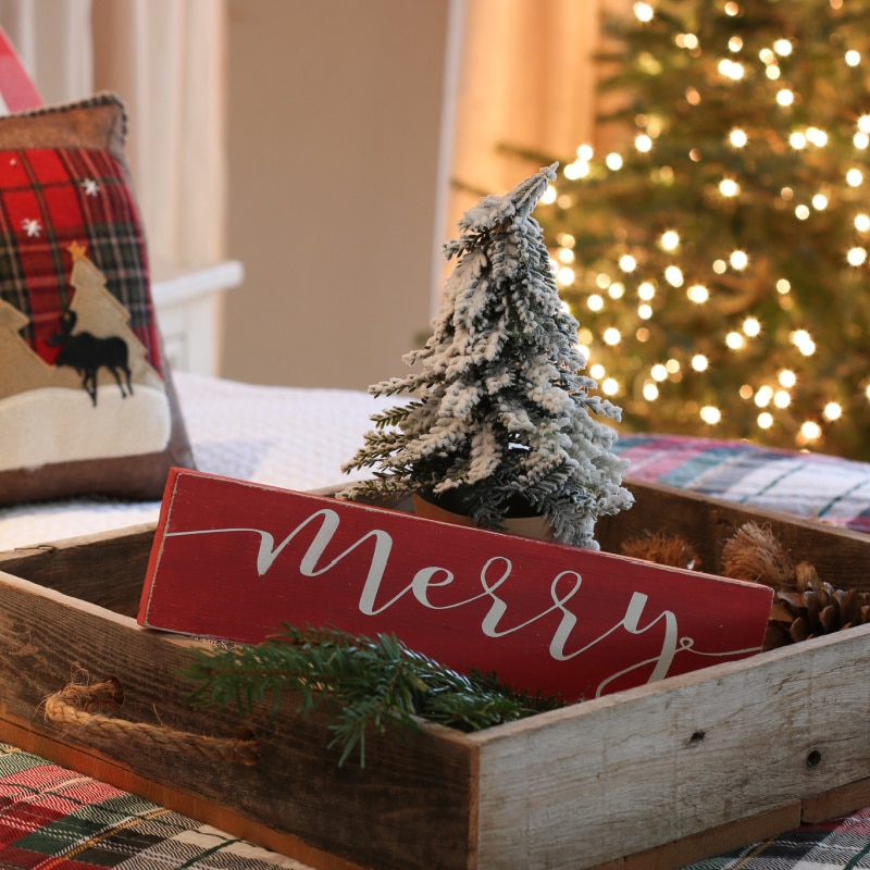 Natural rustic bed tray evergreen and red merry Christmas sign with sparkle of Christmas tree lights