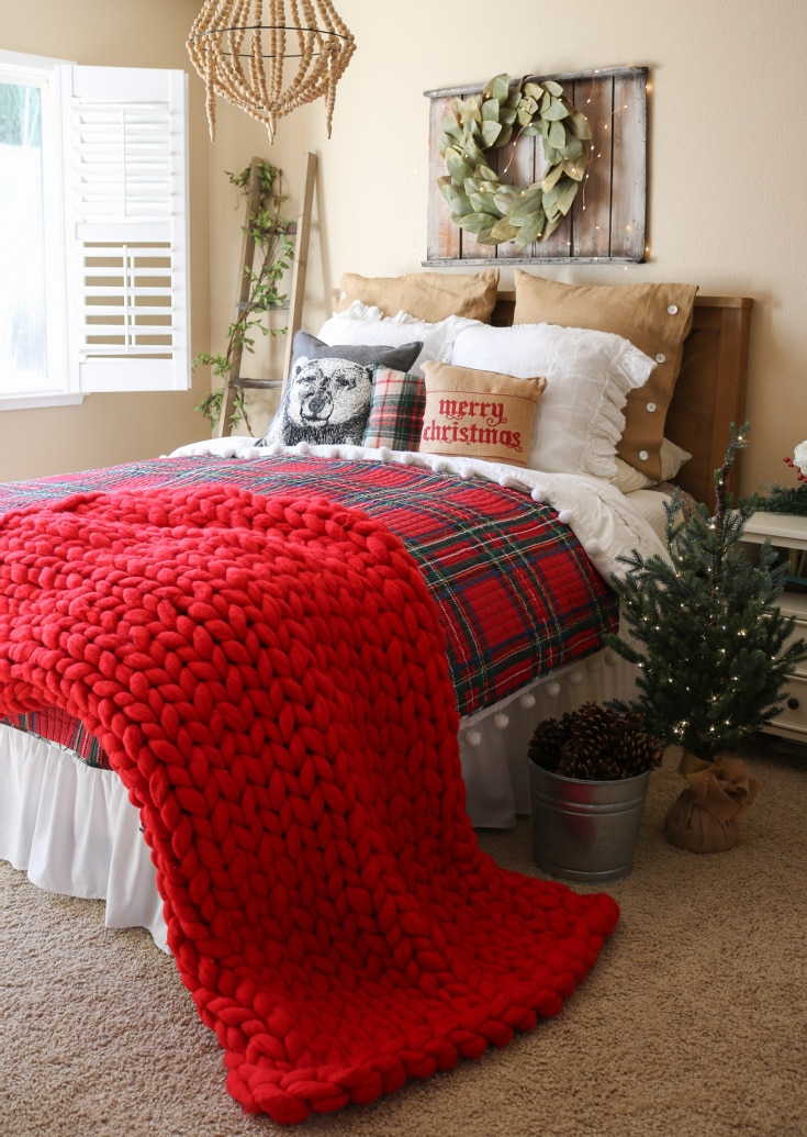 red chunky knit blanket on top of holiday bed