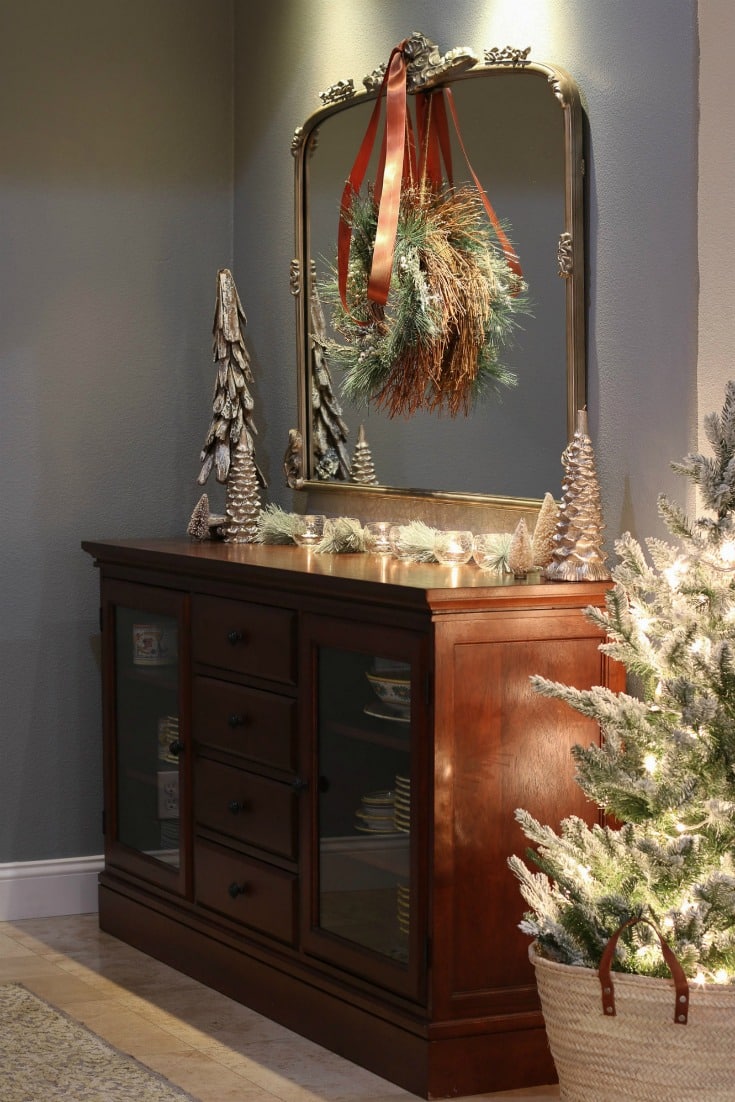 elegant dining room buffet with elegant mirror and mini Christmas tree in a basket