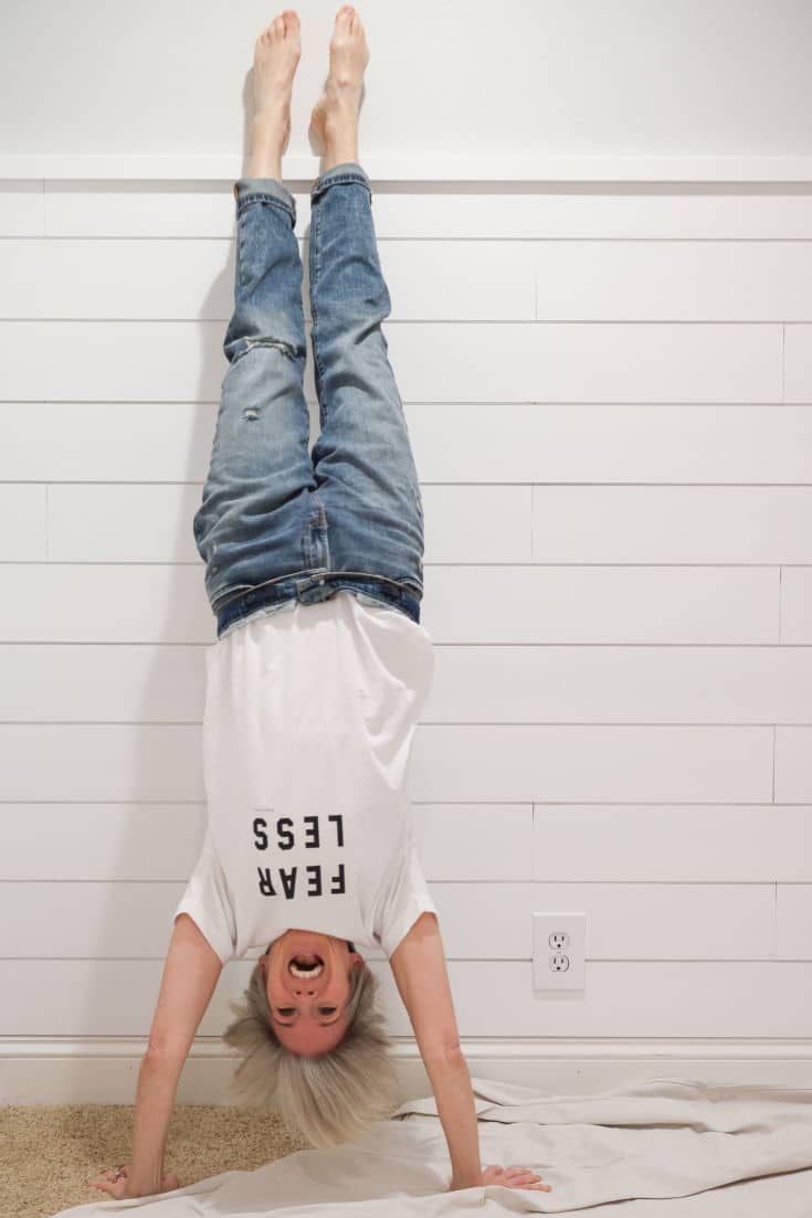 white shiplap walls with woman doing handstand in front