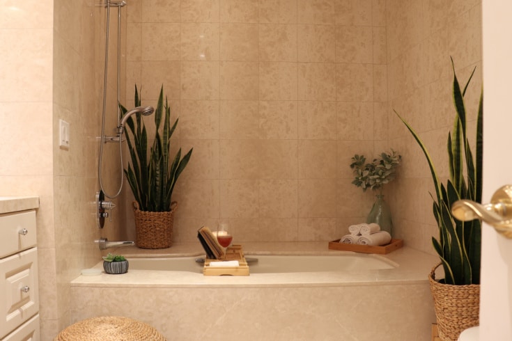 Neutral Natural Boho Bathroom decor with candles, bamboo and woven plant baskets creates relaxing space