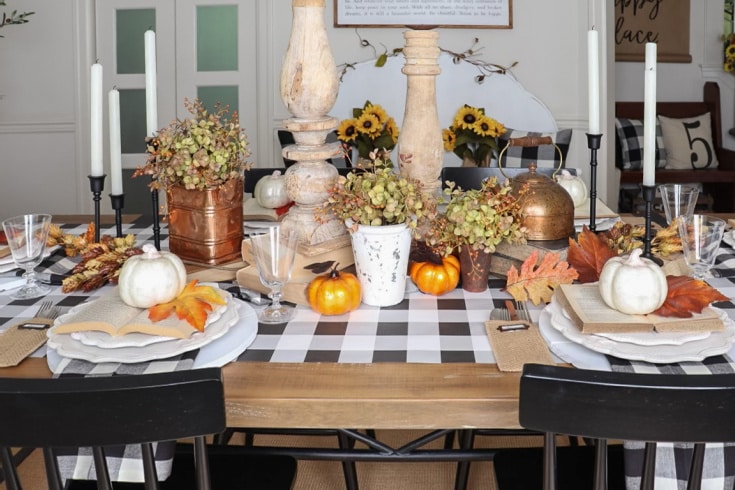 fall table is set with black and white buffalo plaid and natural warm fall colors