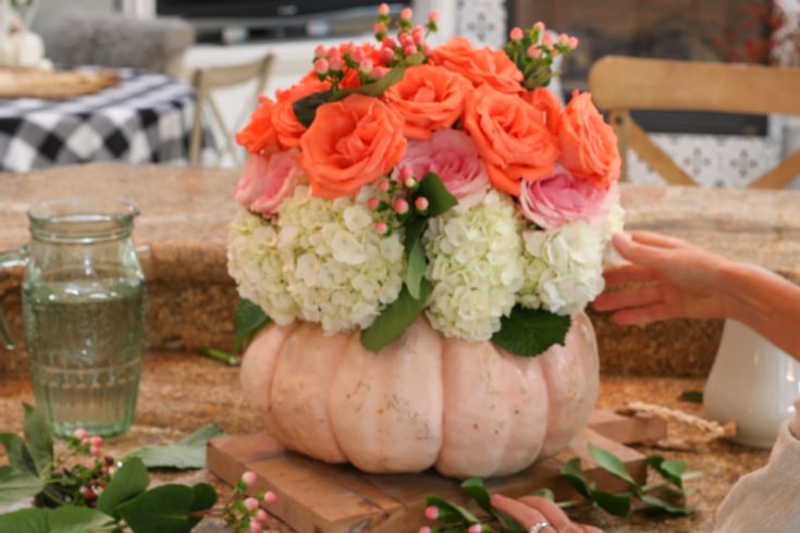 floral bouquet using pumpkin as a vase displays roses and hydrangeas beautifully
