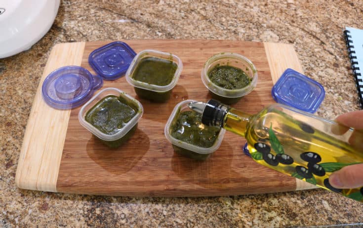 Store single serve containers of basil pesto sauce and seal with olive oil