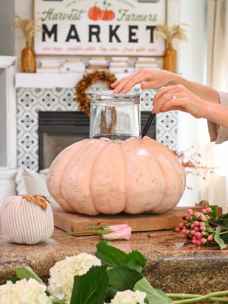 Trace the glass vase around the top of pumpkin to mark where to carve