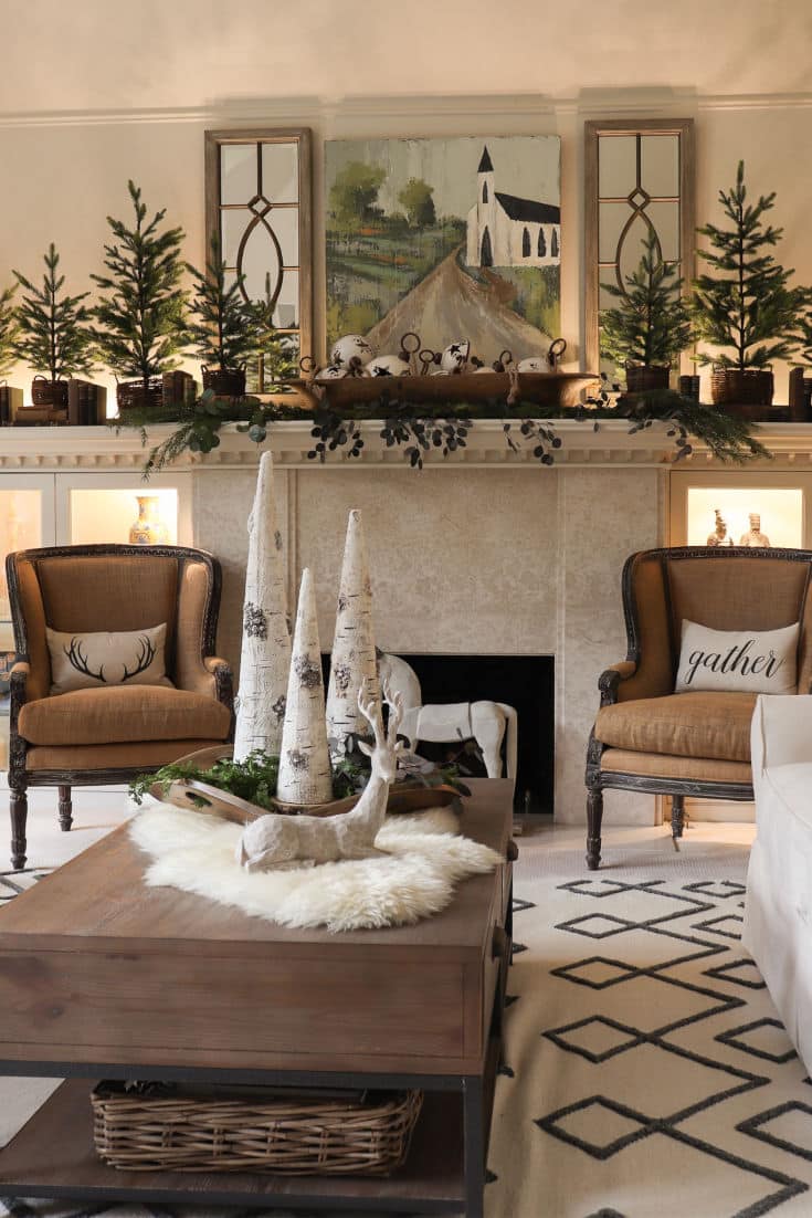 rustic and elegant Christmas mantel decor with evergreen trees and farmhouse painting