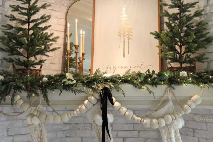 neutral and elegant mantel decor with evergreen and gold decorations