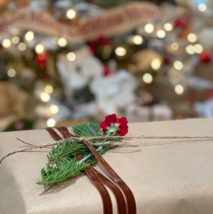 Simple craft paper as gift wrapping gets fancy with velvet ribbon and flower