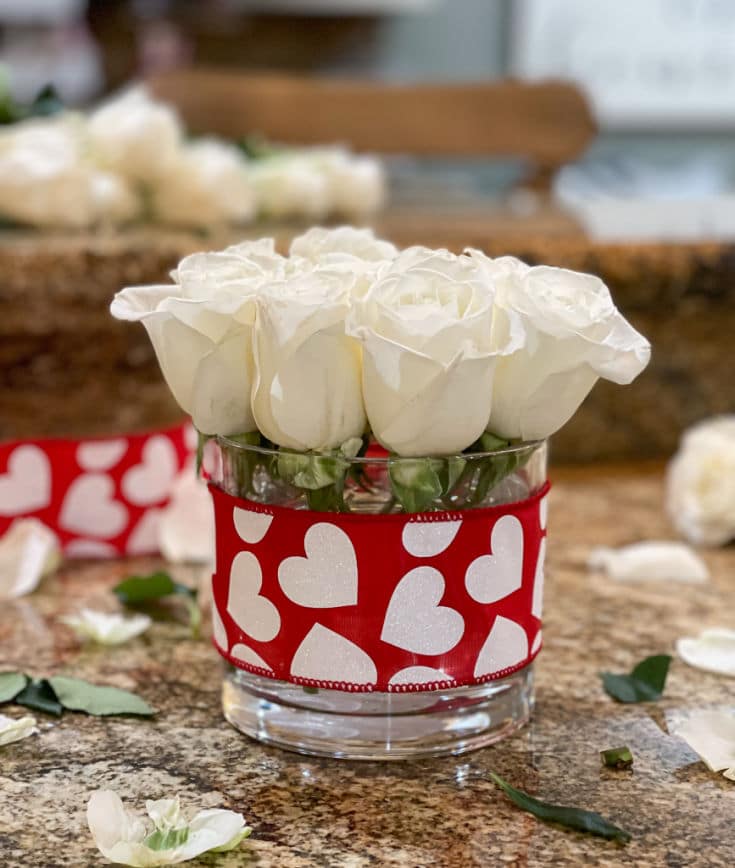 white roses in simple vase with red heart ribbon is easy gift idea