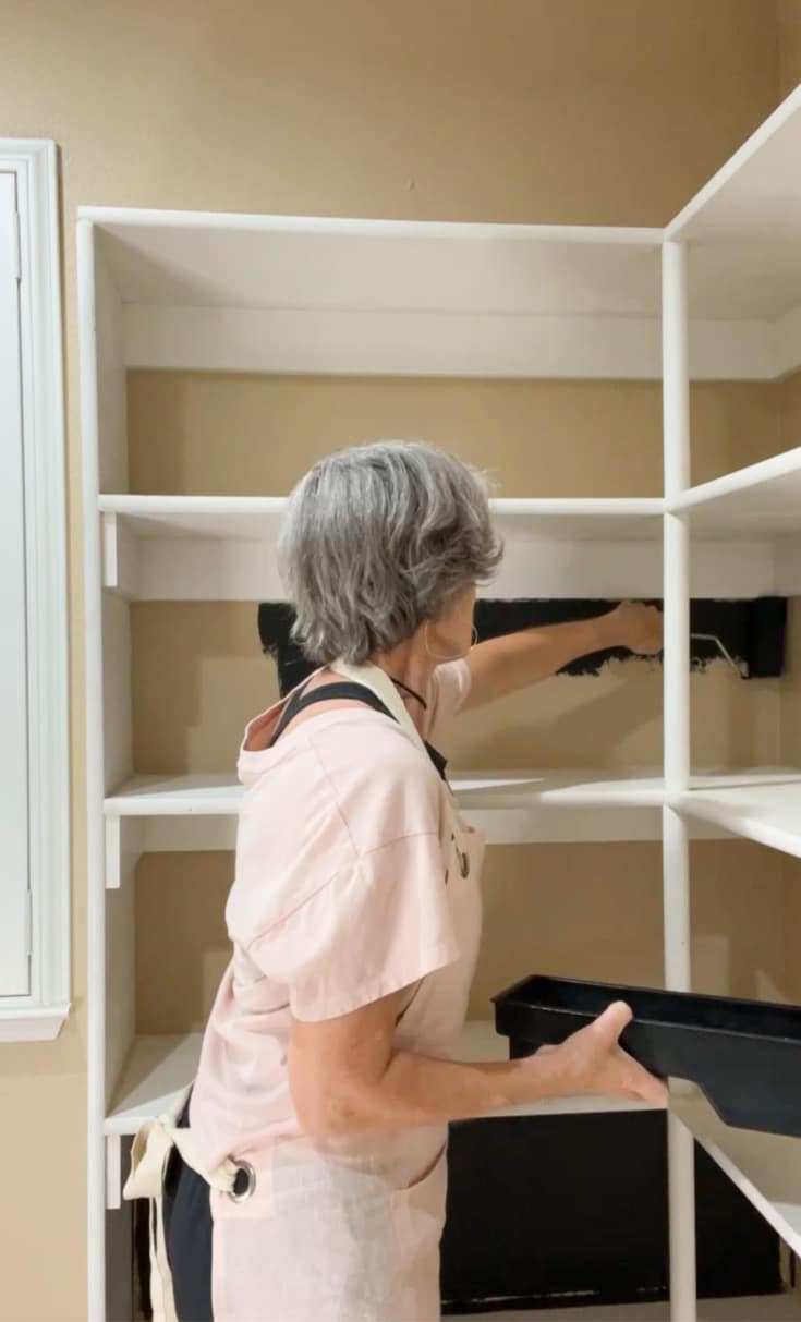 Black painting begins on shelves and walls in budget pantry makeover