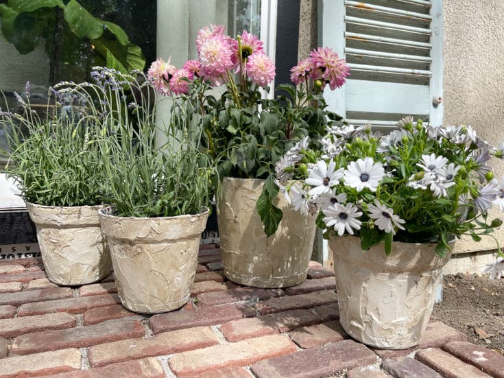 DIY faux stone planters decorating a brick porch