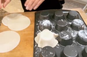 placing pie dough rounds on an upside down muffin tin to create mini pie crusts