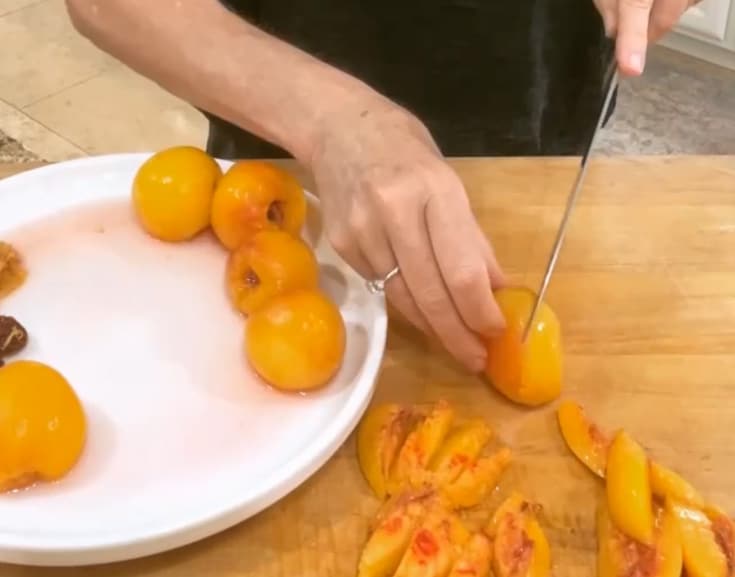 slicing parboiled peaches for a homemade peach pie filling