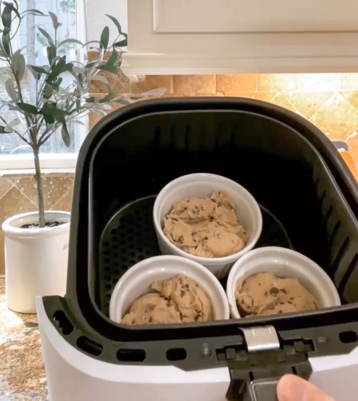placing ramekins filled with pre-made chocolate chip cookie dough into the air fryer