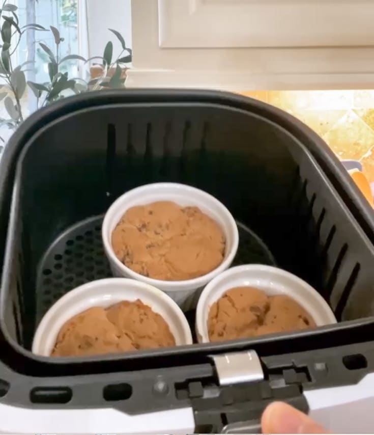 Chocolate chip cookie dough baked in ramekins in a basket style air fryer.