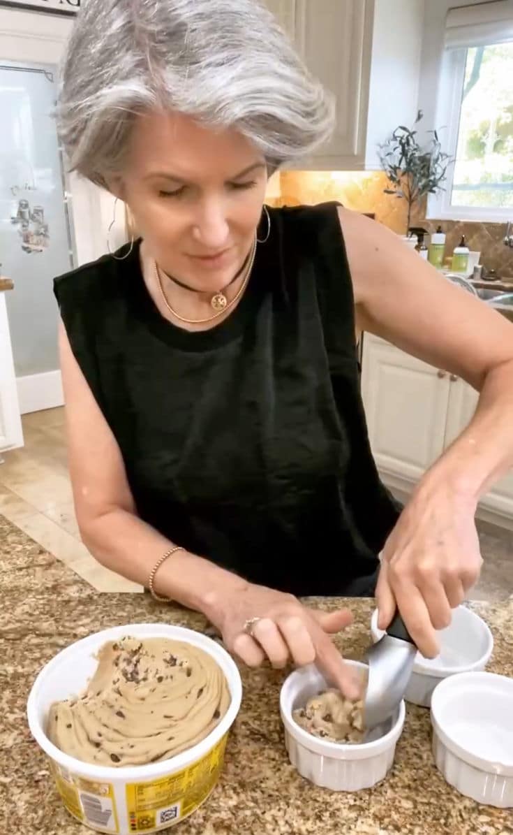 Jodie scooping dough from a container of Toll House Chocolate Chip Cookie Dough, in preparation for Air Fryer chocolate chip cookies