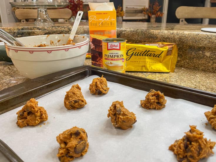 pumpkin spice cookies dough on parchment covered baking sheet with ingredients shown